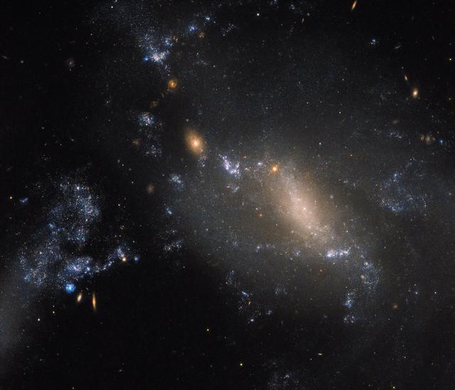 Hubble Sees NGC 3447: 2 Galaxies in a Cosmic Dance Defy Co